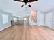 Open-concept living room featuring hardwood floors, stairs, vaulted ceiling, and ceiling fan at 440 Sheppard Xing Ct, Stone Mountain, GA 30083