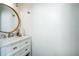 Stylish powder room features modern vanity with marble countertop, brushed nickel fixtures, and a round mirror at 1240 Birchwood Ln, Roswell, GA 30076