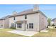 View of the home's exterior with a concrete patio and grass backyard at 2036 Broadmoor Way, Fairburn, GA 30213