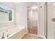 Bathroom with soaking tub, shower and walk-in closet with carpeted floor and wire shelving at 2036 Broadmoor Way, Fairburn, GA 30213