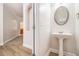Elegant half bathroom with a pedestal sink, decorative mirror, and stylish fixtures at 2036 Broadmoor Way, Fairburn, GA 30213