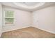 Bedroom featuring neutral walls, carpeted flooring, a window, and a white door at 2036 Broadmoor Way, Fairburn, GA 30213