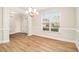 Bright dining room with wood flooring, a chandelier, and decorative molding, plus a large window view at 2036 Broadmoor Way, Fairburn, GA 30213