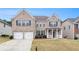 Charming two-story brick home with a well-manicured lawn, two-car garage, and inviting front porch at 2036 Broadmoor Way, Fairburn, GA 30213