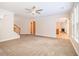 Open living room with neutral carpet and staircase, flowing into other living spaces, and natural light at 2036 Broadmoor Way, Fairburn, GA 30213