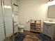 Bathroom with glass enclosed shower, wood-look floors, vanity, toilet, shelving, and dark blue rugs at 5440 Portside Dr, Acworth, GA 30101