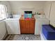 Bright laundry room featuring white subway tiles, washer, dryer, cabinet, and patterned rug at 5440 Portside Dr, Acworth, GA 30101