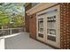 Brick home featuring an outdoor deck with double doors leading inside at 1662 Hartford Ne Gln, Atlanta, GA 30319