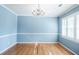 Traditional dining room boasts hardwood floors, chandelier, wainscoting and white trim with blue walls at 2972 Ponderosa Cir, Decatur, GA 30033