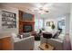 Bright living room with brick fireplace, built-in shelves, ceiling fan, and white furniture at 2972 Ponderosa Cir, Decatur, GA 30033