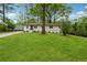 Inviting single-story home with lush green lawn and a tree in the front yard at 1232 Andrews Dr, Marietta, GA 30062