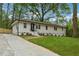 Charming single-story home featuring a black front door, well-kept lawn, and a concrete driveway at 1232 Andrews Dr, Marietta, GA 30062