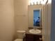 Bathroom with a sink and toilet; dining room visible in the mirror at 1325 Sandlewood Ct, Lithonia, GA 30058