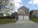 Exterior view of a two-story brick home with attached garage, front lawn, and small bushes at 1325 Sandlewood Ct, Lithonia, GA 30058