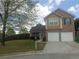 Charming two-story home featuring a brick facade, a two-car garage, and a well-maintained front lawn at 1325 Sandlewood Ct, Lithonia, GA 30058