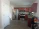 Kitchen features stainless steel appliances, wood cabinets, and gray laminate flooring at 1325 Sandlewood Ct, Lithonia, GA 30058