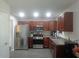 Well-lit kitchen featuring stainless steel appliances and wooden cabinetry at 1325 Sandlewood Ct, Lithonia, GA 30058