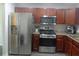 Modern kitchen with stainless steel appliances, dark wood cabinets, and gray countertops at 1325 Sandlewood Ct, Lithonia, GA 30058