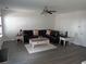 Cozy living room with stylish gray flooring, ceiling fan, and a spacious sectional sofa at 1325 Sandlewood Ct, Lithonia, GA 30058