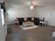 Spacious living room with modern gray flooring, ceiling fan, and a comfortable dark leather sofa at 1325 Sandlewood Ct, Lithonia, GA 30058
