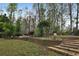 Landscaped backyard featuring a retaining wall, steps, and lush greenery at 159 Molly Way, Mcdonough, GA 30253