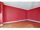 Bright bedroom with hardwood floors and fresh red paint ready for decor at 159 Molly Way, Mcdonough, GA 30253