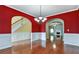 Dining room with hardwood floors and red walls, showcasing archways to other rooms at 159 Molly Way, Mcdonough, GA 30253
