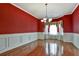 Bright dining room features hardwood floors, white wainscoting, and elegant chandelier at 159 Molly Way, Mcdonough, GA 30253