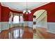 Formal dining room boasts hardwood floors, red walls, and large bay window at 159 Molly Way, Mcdonough, GA 30253