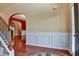 Warm foyer with hardwood flooring, arched doorway, and detailed wall paneling at 159 Molly Way, Mcdonough, GA 30253