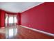 Living room with hardwood floors, red walls, bright windows, and custom window treatments at 159 Molly Way, Mcdonough, GA 30253