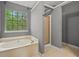 Bathroom features a soaking tub, shower, and large window with backyard views at 3937 Sautee Trl, Conley, GA 30288
