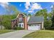 Two-story brick home with an attached two car garage and a long driveway at 3937 Sautee Trl, Conley, GA 30288