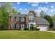Two-story brick home with a well-manicured lawn, red shutters, and attached two car garage at 3937 Sautee Trl, Conley, GA 30288