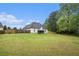 Expansive back yard with a lush green lawn and mature trees, enclosed by a wooden fence at 609 Alyssa Ct, Locust Grove, GA 30248