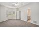 Large bedroom with carpet and tray ceiling, adjacent to the bathroom at 609 Alyssa Ct, Locust Grove, GA 30248
