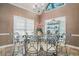 Elegant dining room with large windows, tile floor, and glass-topped table with iron chairs at 125 Russell Rd, Lawrenceville, GA 30043