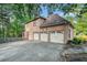 View of the house's back exterior showcasing a three car garage and backyard area at 125 Russell Rd, Lawrenceville, GA 30043