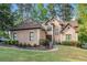 Attractive exterior view of stucco home with manicured lawn, mature trees, and curved sidewalk at 125 Russell Rd, Lawrenceville, GA 30043