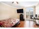 Bedroom with wood floors, a quilt-covered bed, and a door to a balcony at 2161 Peachtree Ne Rd # 402, Atlanta, GA 30309