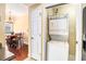 A neatly arranged laundry area with stacked washer and dryer, next to a dining area and kitchen at 2161 Peachtree Ne Rd # 402, Atlanta, GA 30309