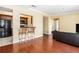 An open-concept living room with hardwood floors, stylish bar stools, and a glimpse of the adjacent kitchen area at 2161 Peachtree Ne Rd # 402, Atlanta, GA 30309