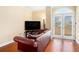 Living room with hardwood floors, a sofa and access to balcony with french doors at 2161 Peachtree Ne Rd # 402, Atlanta, GA 30309