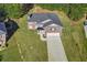 View of a brick home with a large, well-maintained lawn, and private driveway at 4066 Wild Orchid Ln, Loganville, GA 30052