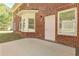 View of the brick house, white back door, and concrete patio at 4066 Wild Orchid Ln, Loganville, GA 30052
