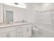 Bright bathroom featuring double vanity with granite counters, and a white shower-tub combo at 4066 Wild Orchid Ln, Loganville, GA 30052