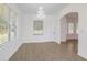 Light-filled dining room with wood-look tile floors and modern chandelier at 4066 Wild Orchid Ln, Loganville, GA 30052