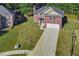 Aerial view of a brick home showcasing the well-kept lawn and lengthy driveway at 4066 Wild Orchid Ln, Loganville, GA 30052