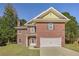 Charming two-story brick home featuring manicured lawn and attached two-car garage at 4066 Wild Orchid Ln, Loganville, GA 30052