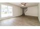 Open-concept living area with hardwood floors, a ceiling fan, and ample natural light from the large window at 4437 James Wade Dr, Snellville, GA 30039